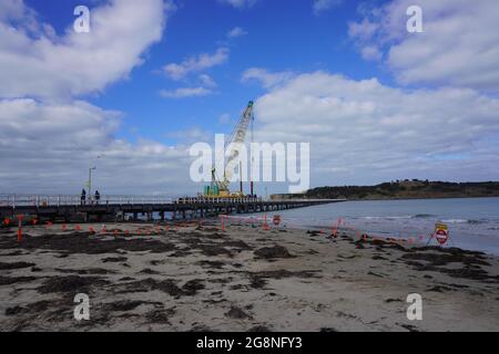 Grue de construction s'est engagée dans la construction d'une nouvelle chaussée à côté de la chaussée de l'Old Granite Island Banque D'Images