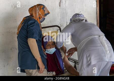 Kuala Lumpur, Malaisie. 21 juillet 2021. Un travailleur médical injecte une dose de vaccin COVID-19 pour un résident local dans la zone rurale du district de Sabak Bernam, Selangor, Malaisie, le 21 juillet 2021. Selon le Ministère de la santé, la Malaisie a enregistré mercredi un nouveau record de 199 décès d'un jour par rapport à la COVID-19, portant le nombre total de décès à 7,440. Credit: Chong Voon Chung/Xinhua/Alay Live News Banque D'Images