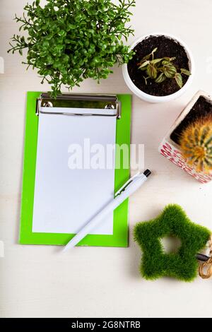 Fleurs intérieures et papier à lettres sur fond en bois. Soin des fleurs à l'intérieur. Banque D'Images
