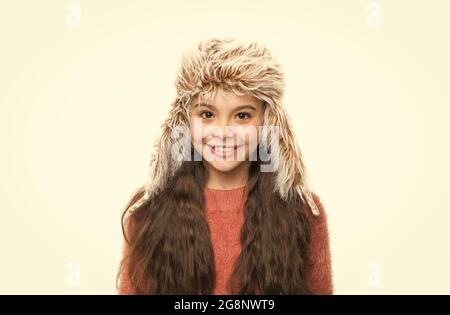 chaleur sans saison. dernières tendances cet hiver. joyeux enfant porte un chapeau à rabat. ambiance de noël. cheveux longs pour petite fille isolés sur du blanc. chaud et confortable Banque D'Images