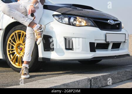 Kiev, Ukraine - 25 mars 2015: Subaru Impreza WRX STI. Fille en baskets de couleur et en pantalon blanc. Fille sur fond de voiture. Voiture et fille Banque D'Images