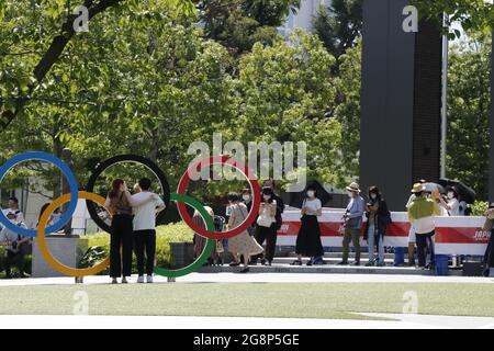 Les gens attendent de prendre une photo avec les anneaux olympiques devant le Stade National, le principal lieu des Jeux Olympiques de Tokyo en 2020. Banque D'Images