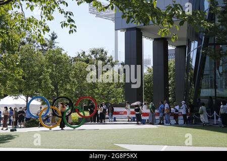 Les gens attendent de prendre une photo avec les anneaux olympiques devant le Stade National, le principal lieu des Jeux Olympiques de Tokyo en 2020. Banque D'Images