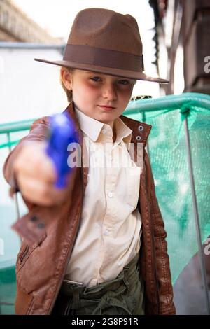 Glasgow, Écosse, Royaume-Uni. 21 juillet 2021. PHOTO : Indiana Jones a vu passer le jeu de films. En fait, c'est peu Indy, Isla qui est habillée comme Indy visitant le set avec son père Alastair. Filmer sur le set de l'Indiana Jones 5 au milieu du centre-ville de Glasgow alors que le superproduction hollywoodienne établit Glasgow comme la ville de New York. Une production complète peut être vue, avec une grande coulée, des producteurs et des extras. Le centre-ville a été modifié de sorte que tous les magasins et le bâtiment ressemblent à 1959 Amérique. Crédit : Colin Fisher Banque D'Images