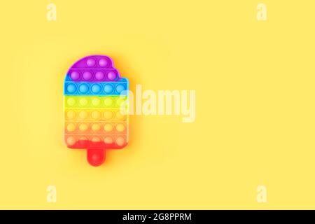 Poussez le jouet de violon pop isolé sur fond jaune. Banque D'Images