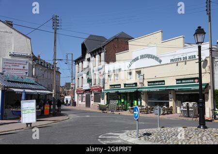 Rue du village, le Crotoy, avec des cafés vendant de petites moules bouchotes récoltées dans les marais salants de la Baie de la somme, Picardie, France. Banque D'Images