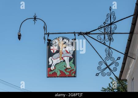 Panneau de pub George House sur un support en fer forgé très orné dans le village de Hambledon, dans le Hampshire, avec St George et le Dragon, Angleterre, Royaume-Uni Banque D'Images