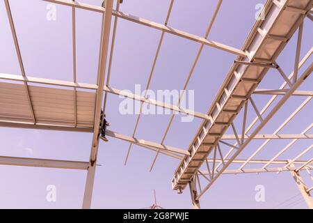 Travailleur de la construction assis sur la structure de treillis et de cadre en acier léger. Banque D'Images