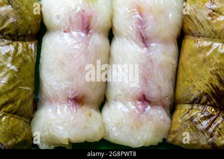 Un jet de riz gluant dans une feuille de banane ou un tapis Khao tom. Thaï rempli de lait de coco et de banane. Banque D'Images