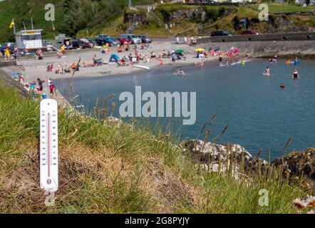 Plage bondée avec thermomètre en avant-plan montrant une journée très chaude Banque D'Images