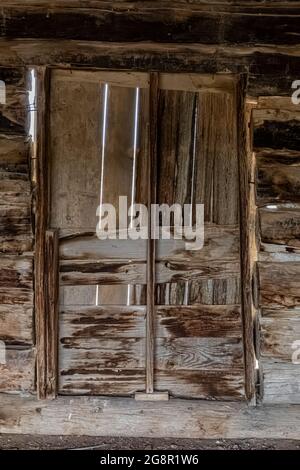 Weatherd vieille porte sur une cabane en rondins au ML Ranch dans le terrain de loisirs national de Bighorn Canyon, Wyoming, États-Unis Banque D'Images