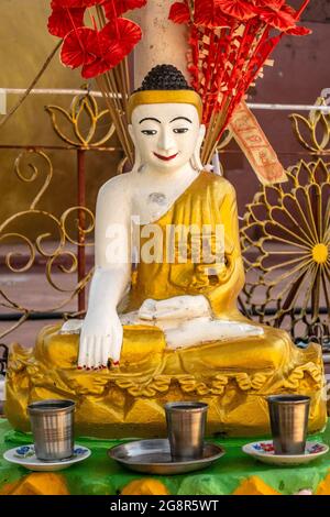 Bonne chance en versant de l'eau sur la tête de la statue de Bouddha, Myanmar Banque D'Images