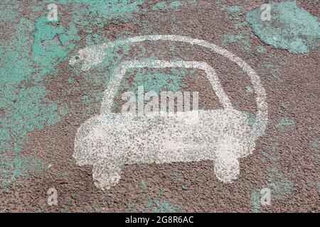 Un panneau blanc usé et décoloré sur le tarmac pour l'espace de chargement électrique de voiture Banque D'Images