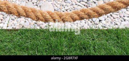 Corde grossière avec fond de gravier blanc et herbe en dessous Banque D'Images