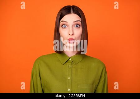 Photo de brunette impressionnée coiffo jeune femme porter une chemise kaki isolée sur fond de couleur orange Banque D'Images
