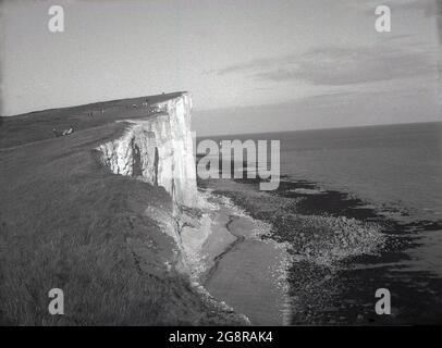 Années 1950, photo historique de Beachy Head sur les South Downs près d'Eastbourne, East Sussex, Angleterre, Royaume-Uni, vu de l'ouest. Le rocher ou le phare off-shore peut être vu dans la mer au loin. La plus haute falaise de la mer de craie en Grande-Bretagne, le promontoire est un endroit célèbre pour la marche de plaisir, avec une vue magnifique sur la Manche. Une région d'une beauté naturelle exceptionnelle, une loi du Parlement britannique de 1929 a permis l'achat des terres pour protéger et protéger leur utilisation pour les générations futures. Banque D'Images