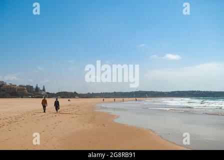 Personnes marchant le long de la plage de sable chaud, une image formant une palette de couleurs naturelles, grand plan - Portugal, Portimao Banque D'Images