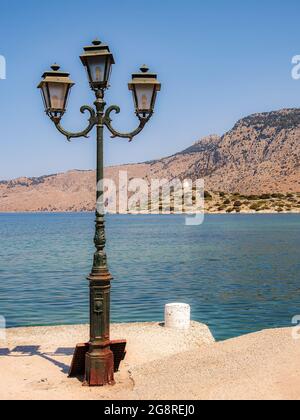 SYMI, GRÈCE - 09 JUILLET 2021 : le moulin à vent qui vous accueille à l'entrée du port au monastère de la ville grecque de Symi. Banque D'Images