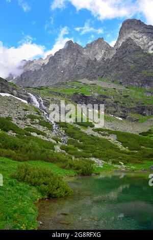 Paysage dans les Hautes Tatras avec les montagnes, le lac de Velicke pleso et la cascade Vélicky vodopad. Slovaquie. Banque D'Images