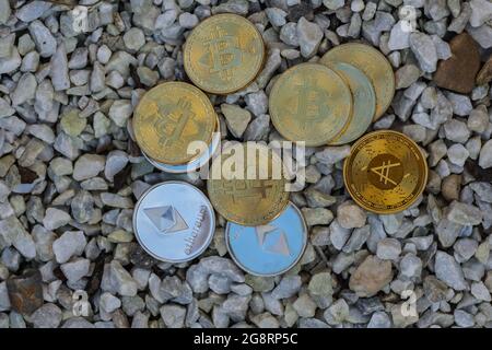 beaucoup de pièces d'or et d'argent valant l'éther bitcoin et ada de crypto-monnaie se trouvant sur une vue de gravier blanc d'en haut Banque D'Images