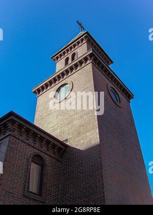 Vieille église dans les rayons du soleil couchant. Église sur fond de ciel bleu clair. Banque D'Images