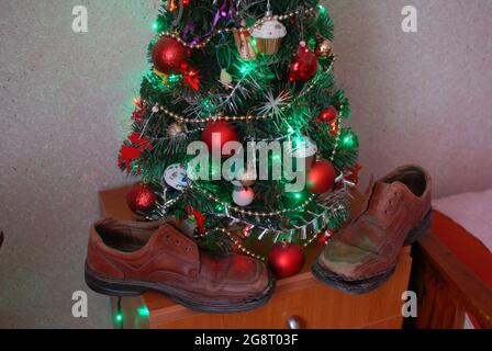 Vieilles chaussures, trous dans les chaussures et roses, roses, arbre de noël, Banque D'Images