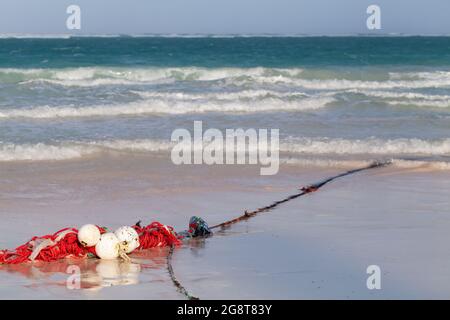 Le blanc rouge flotte sur une corde au-dessus de la côte de sable humide de la plage de Bavaro, République dominicaine Banque D'Images