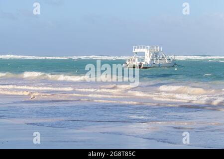 Paysage côtier des Caraïbes. Bateau à moteur blanc de plaisir est amarré près de la plage de Bavaro, République dominicaine Banque D'Images