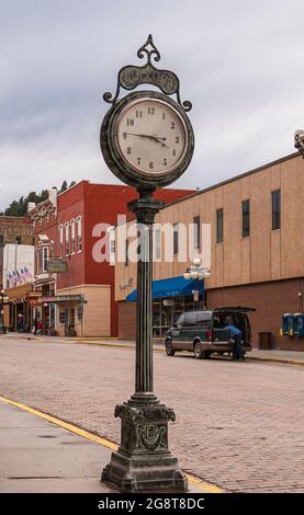 Deadwood SD, États-Unis - 31 mai 2008 : Downtown main Street. Horloge circulaire autonome sur le trottoir avec nom Bullock sur le dessus avec des bâtiments d'affaires à ba Banque D'Images