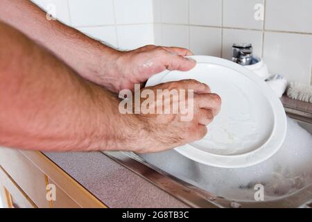 homme lavant la vaisselle Banque D'Images