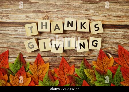 Bonne lettre de l'alphabet Thanksgiving avec des feuilles d'automne sur fond en bois Banque D'Images