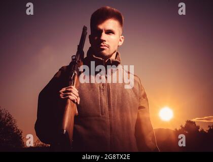 Équipement de chasse à vendre. Fusil Hunter silhoueté dans beau coucher de soleil. Chasse sans frontières. Portrait de Hunter. Banque D'Images