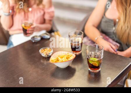 Vue rognée de quelques boissons et en-cas consommés par des amis adultes Banque D'Images