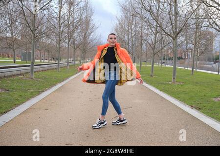 Un jeune homme qui porte du maquillage danse dans un parc. Rotation. Banque D'Images