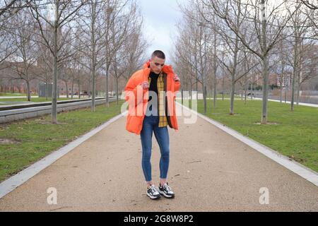 Un jeune homme qui porte du maquillage danse dans un parc. Danse fraîche. Banque D'Images