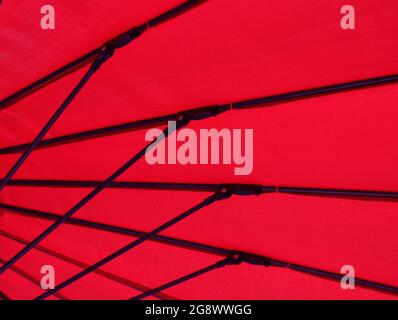 Image géométrique du dessous d'un parasol en tissu rouge Banque D'Images