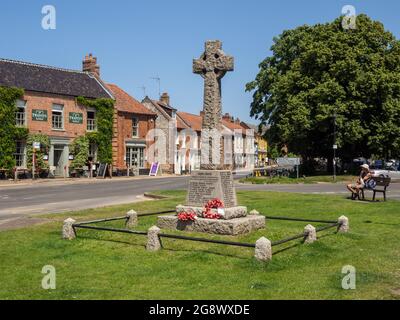 Scène de rue en été dans le joli village de Burnham Market, Norfolk, Royaume-Uni; village vert avec mémorial de guerre Banque D'Images