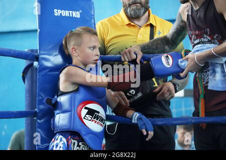 ODESA, UKRAINE - 22 JUILLET 2021 - UN garçon se fixe son gant dans le coin de l'anneau pendant le Championnat thaïlandais de Muay d'Ukraine à Odesa, au sud Banque D'Images