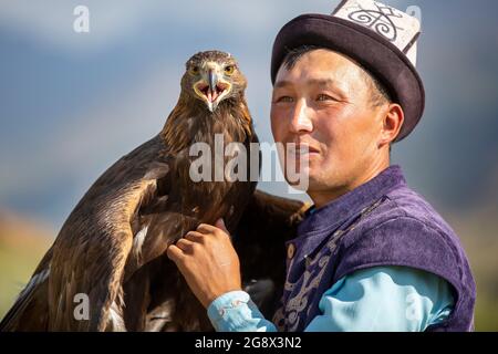 Chasseur d'aigle et son aigle d'or à Issyk Kul, Kirghizistan Banque D'Images