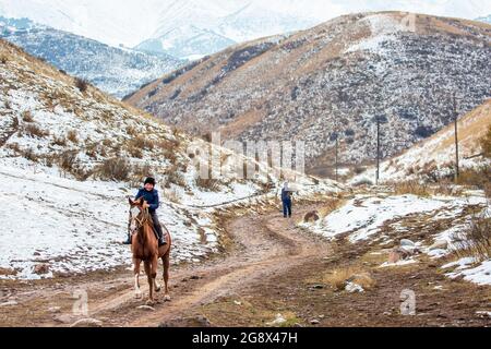 Jeune garçon nomade à cheval près de Bichkek, Kirghizistan Banque D'Images