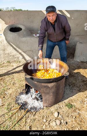 L'ouzbek cuisent des légumes dans une grande casserole à l'extérieur, dans la banlieue de Samarkand, en Ouzbékistan Banque D'Images