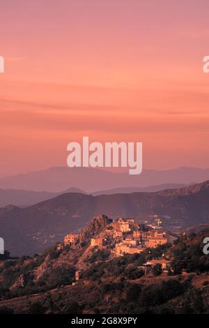 Soleil du soir sur l'ancien village de montagne de Speloncato dans la région de Balagne en Corse avec Cap Corse au loin Banque D'Images