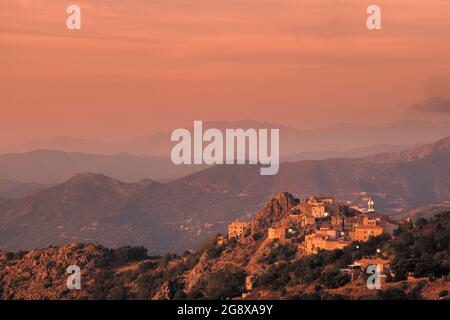 Soleil du soir sur l'ancien village de montagne de Speloncato dans la région de Balagne en Corse avec Cap Corse au loin Banque D'Images