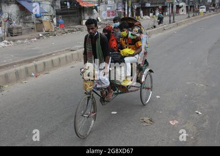 Dhaka, Bangladesh. 23 juillet 2021. Un extracteur de pousse-pousse transporte le passager de retour à la maison le premier jour d'un verrouillage plus strict à Dhaka. (Image de crédit : © MD Mehedi Hasan/ZUMA Press Wire) Banque D'Images