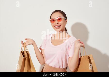 Belle jeune femme asiatique tenant un sac de shopping, souriant avec une bonne humeur, les achats gaies dans Holiday at Mall Banque D'Images