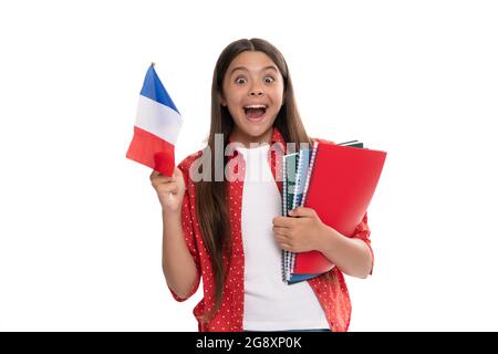 un enfant émerveillé tient le drapeau français et le livre d'or de l'école pour étudier isolé sur blanc, étudier à l'étranger Banque D'Images