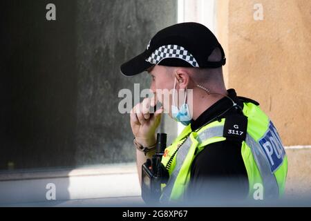 Glasgow, Écosse, Royaume-Uni. 22 juillet 2021. PHOTO : un policier écossais est vu sur le terrain pour parler d'une bouffée sournoise sur une E-cigarette pendant son travail, Vu d'un appartement à Parnie St. le tournage du nouveau film Indiana Jones 5 au milieu du centre-ville de Glasgow s'est déplacé dans le quartier de la ville marchande alors que le superproduction hollywoodienne a établi Glasgow comme une Amérique des années 1950/1960. Les acteurs acteurs de cinéma, de premier plan et de soutien, ainsi que l'équipe de production, les réalisateurs et les coureurs, peuvent être vus sur et en dehors du tournage. Crédit : Colin Fisher Banque D'Images