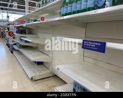 Vider les étagères dans l'allée d'eau du magasin Tesco à St Rollox à Glasgow. Des pressions s'exercent sur le gouvernement pour qu'il avance la date à laquelle les personnes qui sont vaccinées deux fois contre le coronavirus peuvent éviter l'auto-isolement, car des mesures d'urgence pour protéger les approvisionnements alimentaires ont été lancées jeudi. Date de la photo : vendredi 23 juillet 2021. Banque D'Images