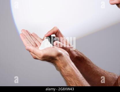 Un homme qui se moque de la mousse de rasage dans sa main. Toilettage masculin. Rasage. Banque D'Images