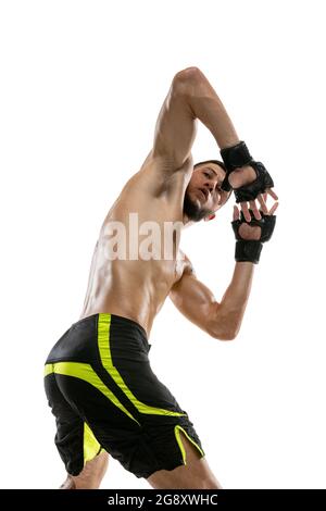 Un homme, un boxeur professionnel MMA mâle en mouvement isolé sur fond blanc de studio. Faire des combats musculaires d'athlète caucasien. Banque D'Images